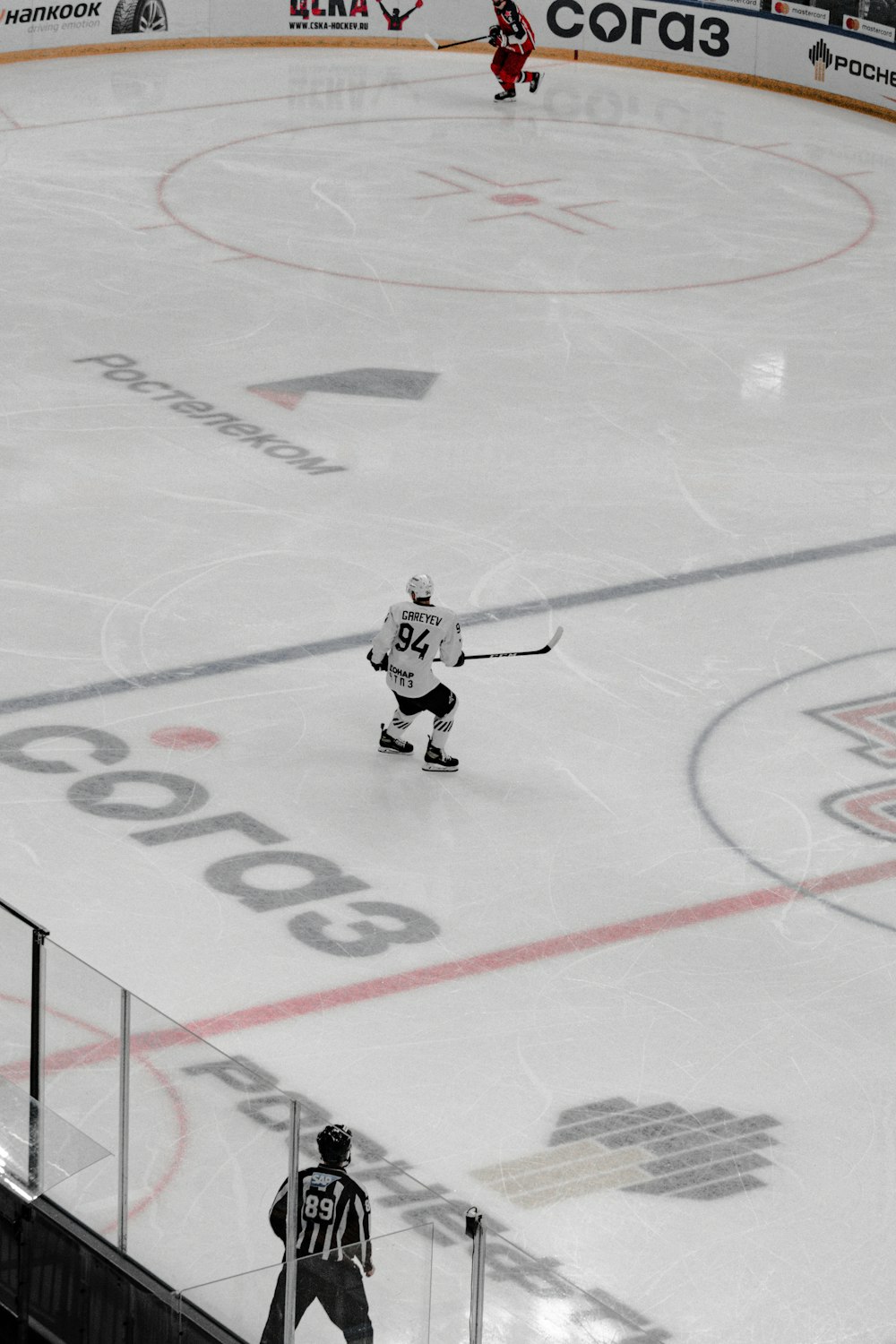 hombre en camiseta de hockey sobre hielo blanco y negro montando en tablero de hockey