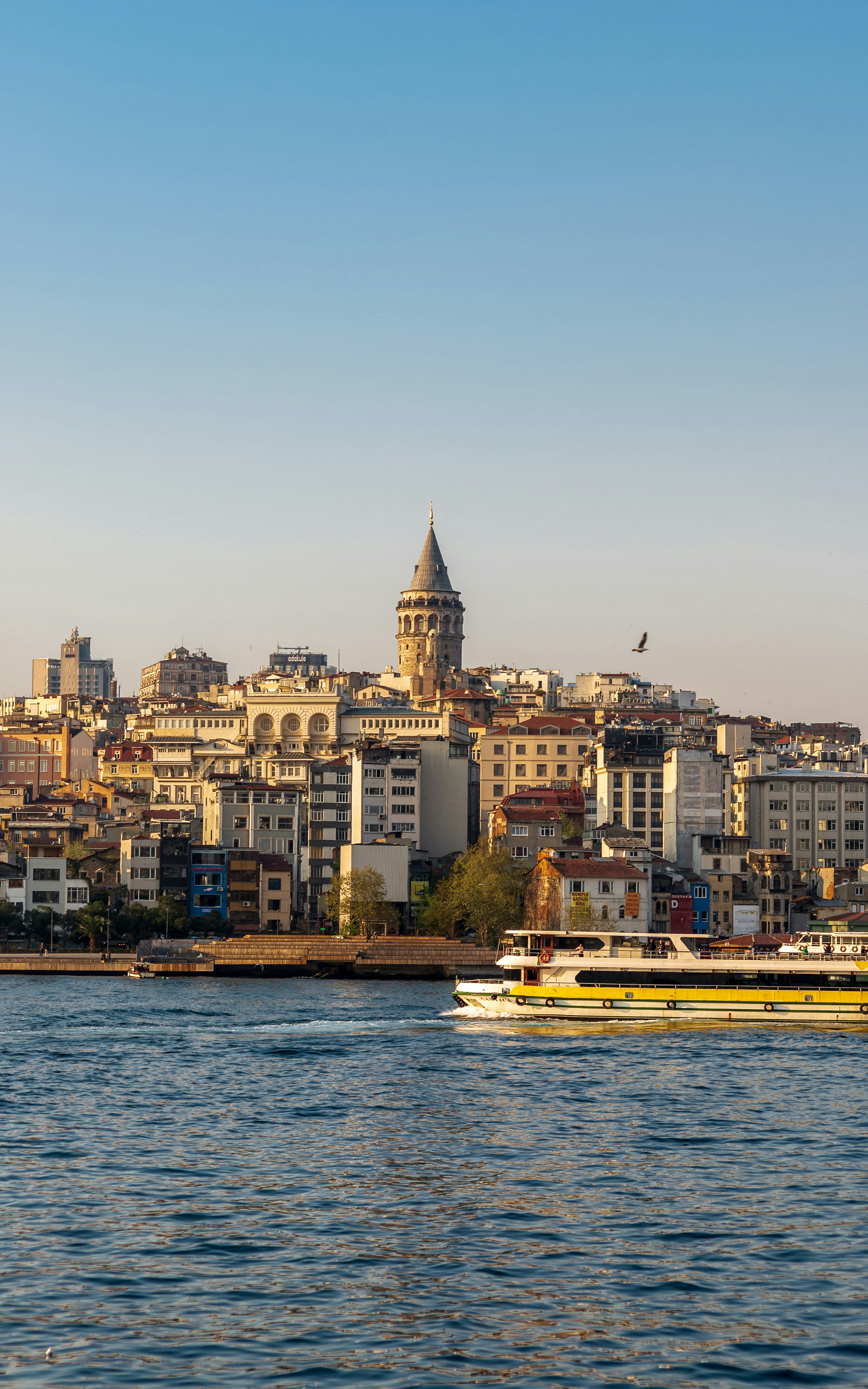 white and yellow boat on water near city buildings during daytime