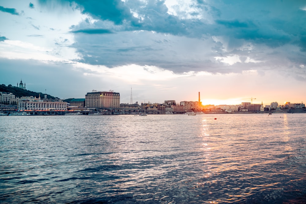 city skyline across body of water under blue and white sunny cloudy sky during daytime