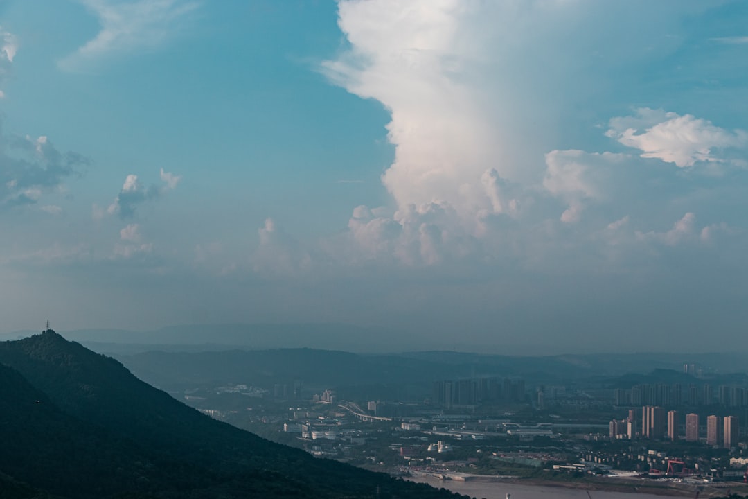 city buildings under white clouds and blue sky during daytime