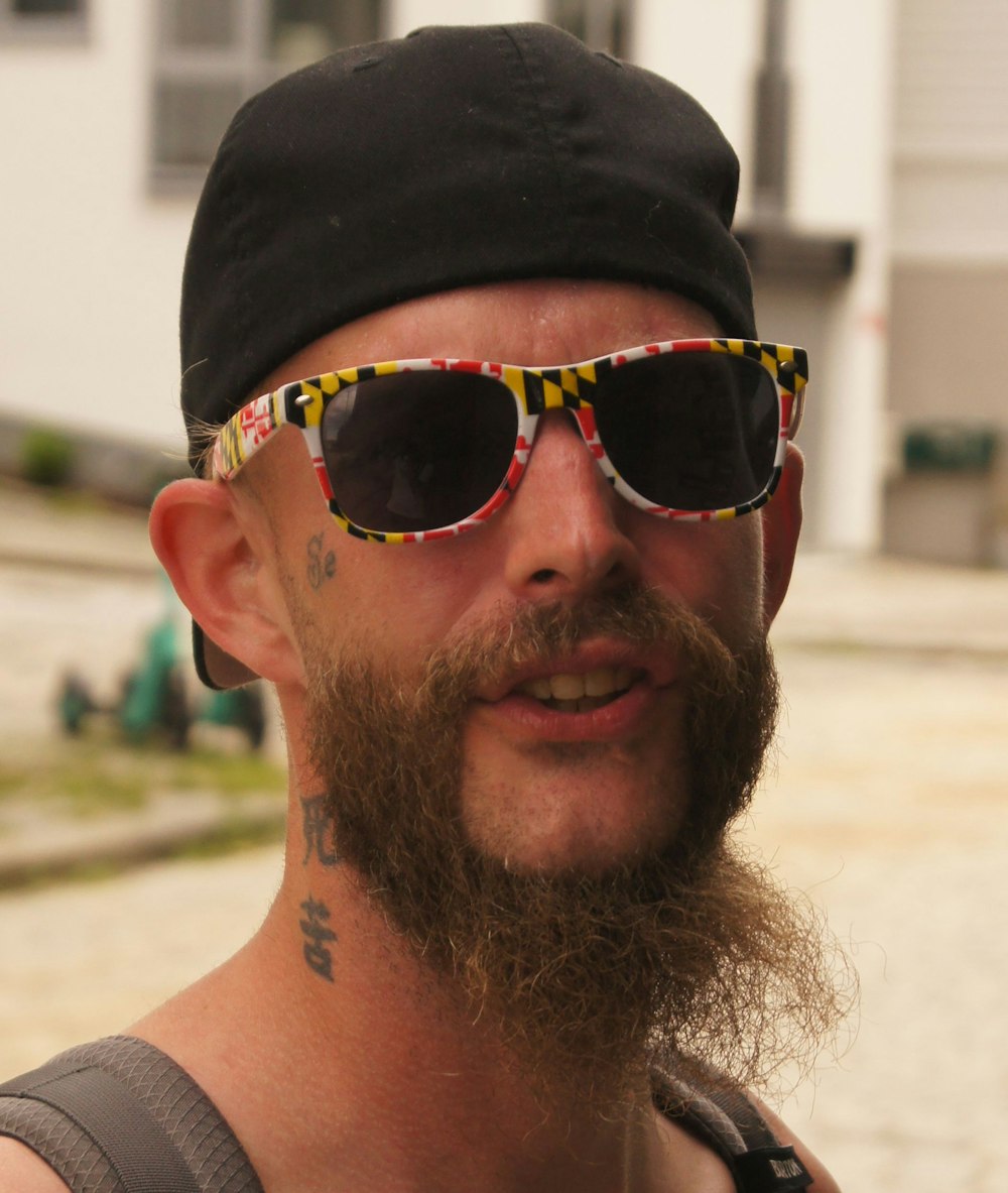 man wearing black sunglasses and black cap