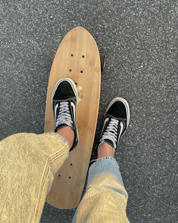 A skater wearing trendy clothes and sneakers, standing next to a half-pipe
