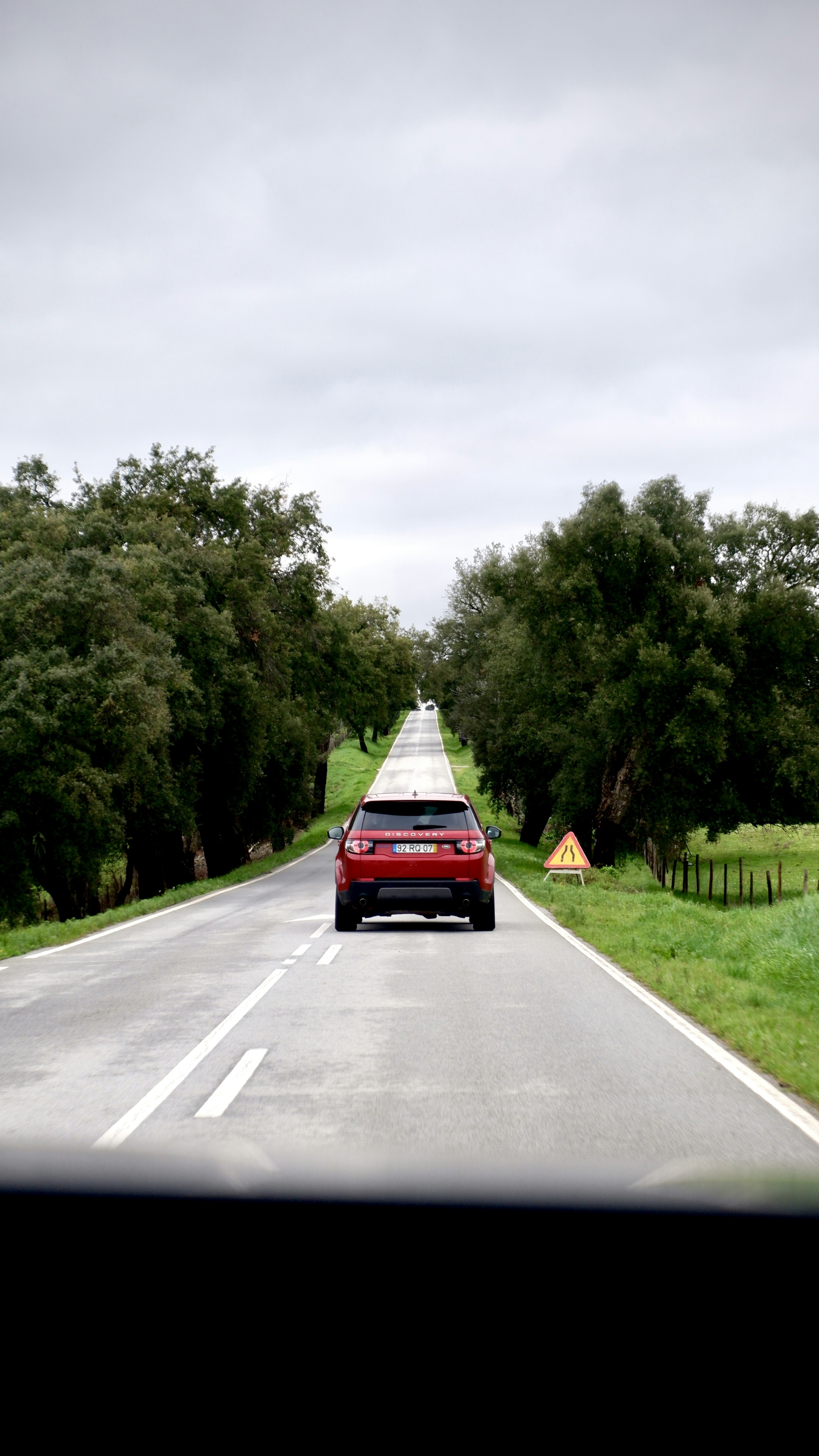 red car on gray asphalt road during daytime