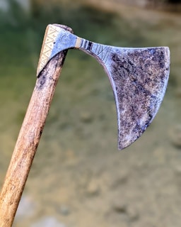 brown wooden handle axe in grayscale photography