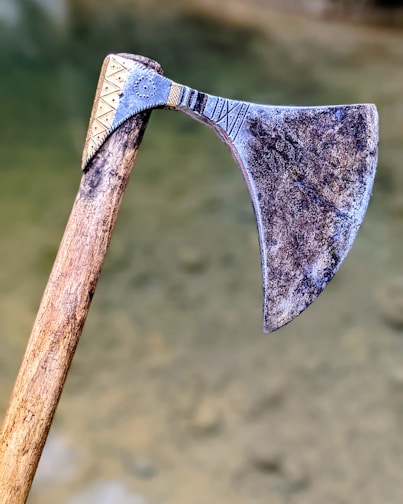 Intricately carved Viking axe resting on a crimson cloth with black and gold accents.