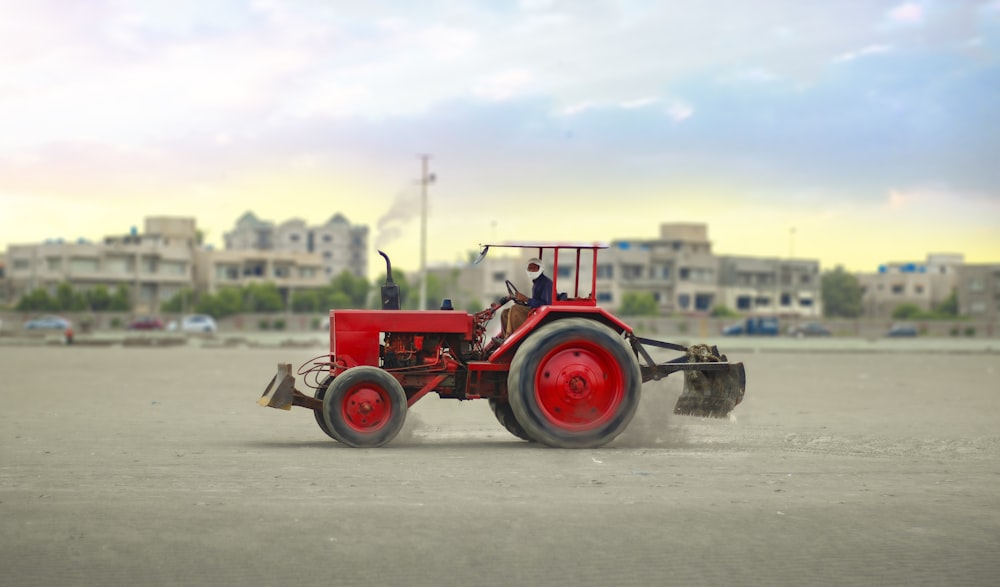 red tractor on gray road during daytime