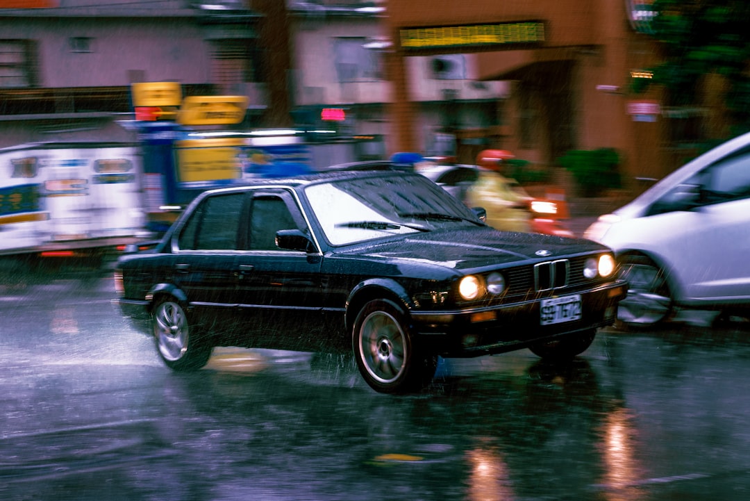 black sedan on wet road during night time