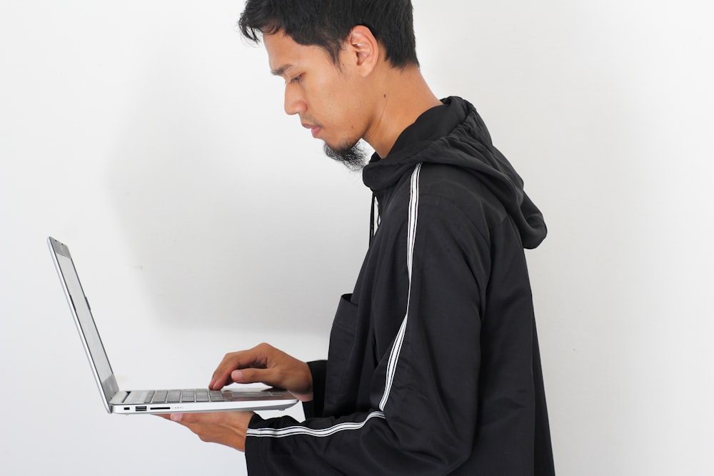 man in black hoodie using tablet computer