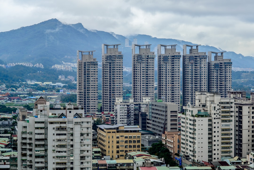 high rise buildings near mountain under white clouds during daytime