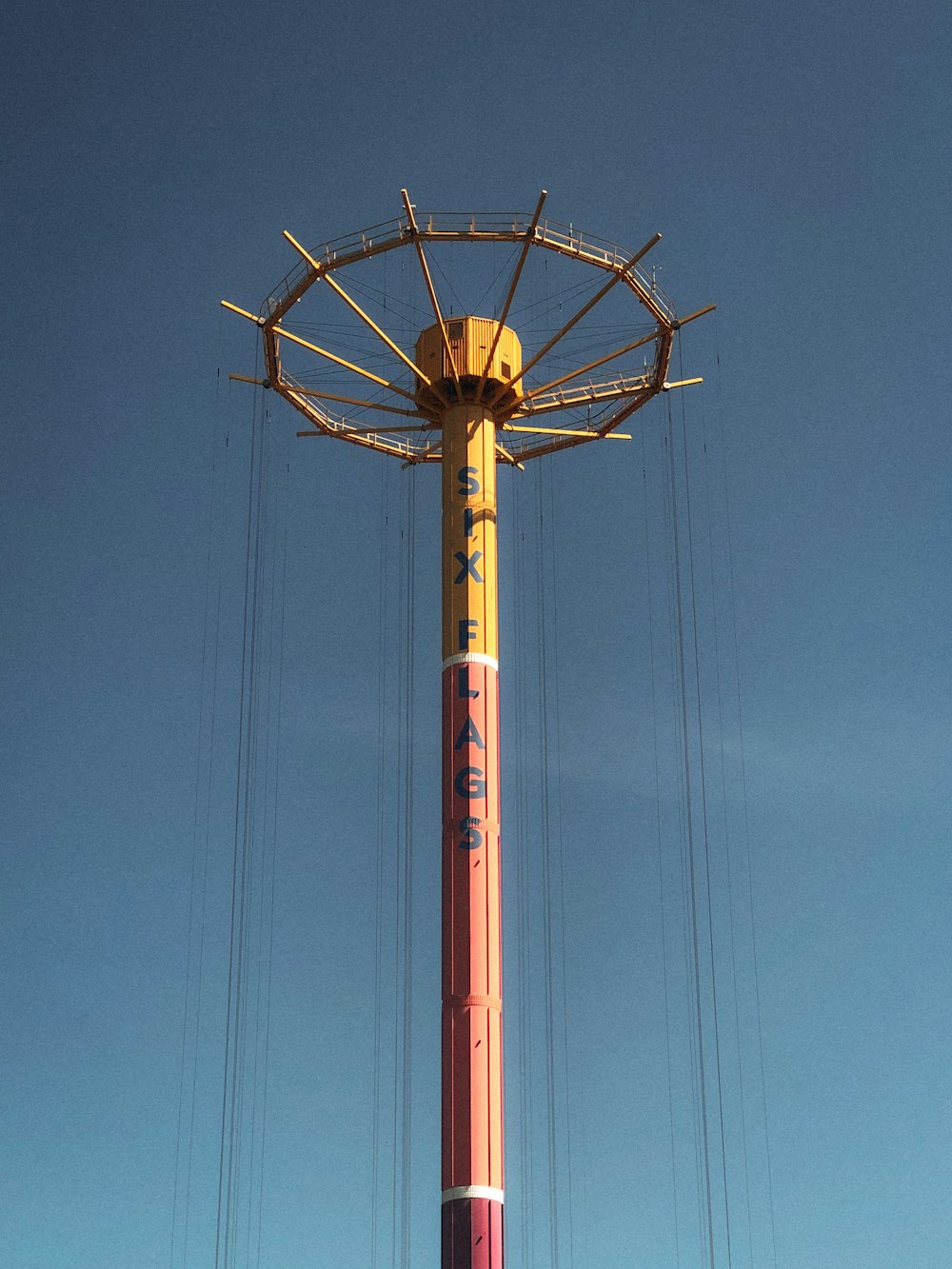 torre de metal vermelha e branca sob o céu azul durante o dia