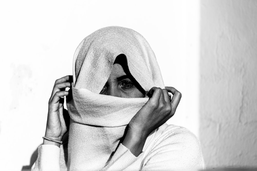 mujer con hiyab blanco cubriendo su rostro con tela blanca