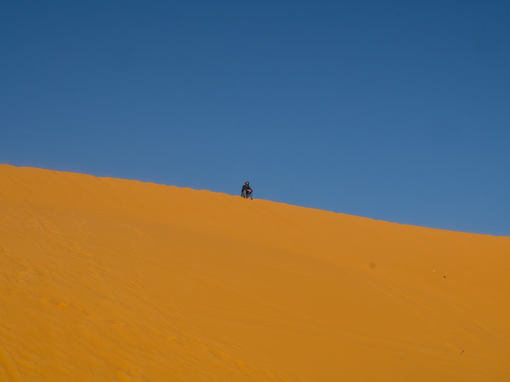 person riding camel on desert during daytime