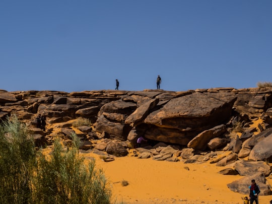 people walking on brown sand during daytime in Taghit Algeria