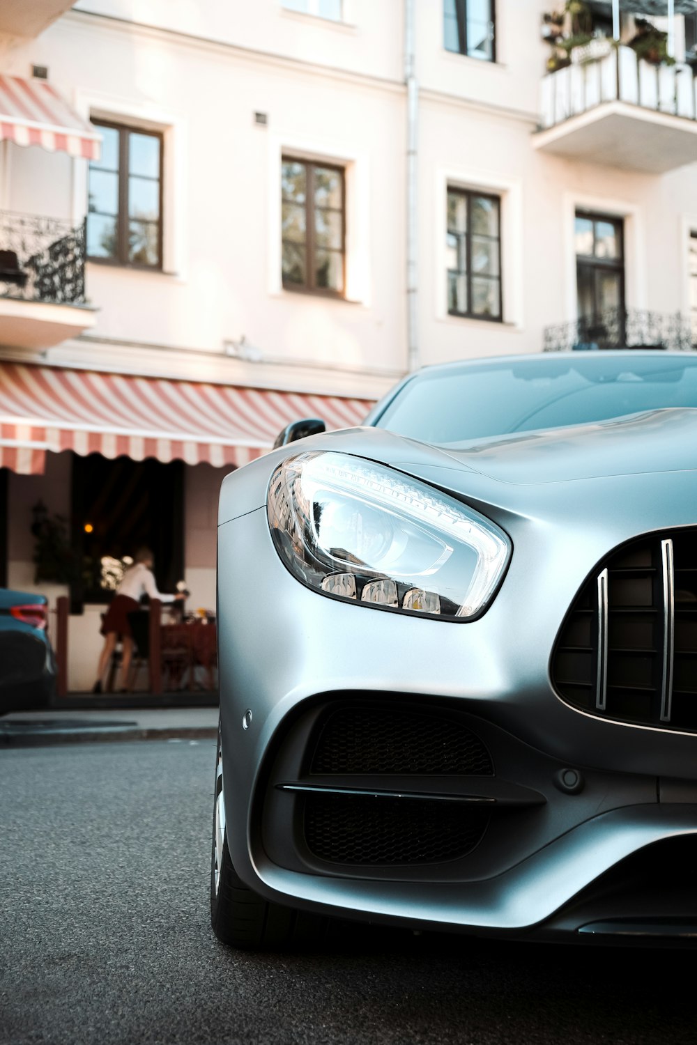 white mercedes benz car in front of people walking on street during daytime