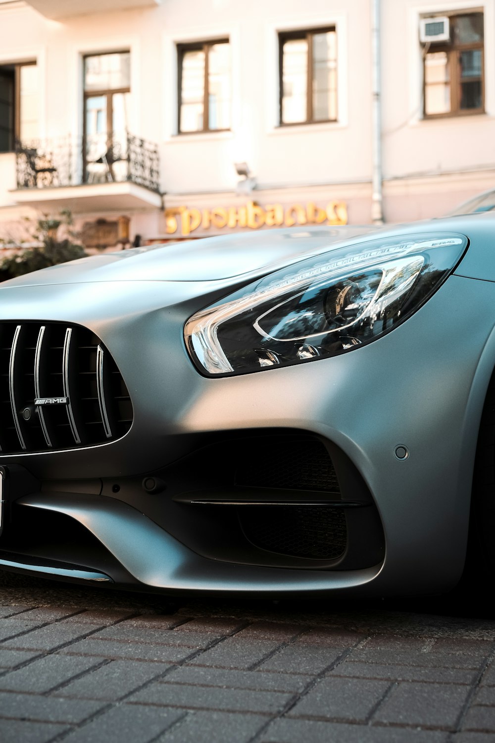 silver mercedes benz car in front of brown building during daytime