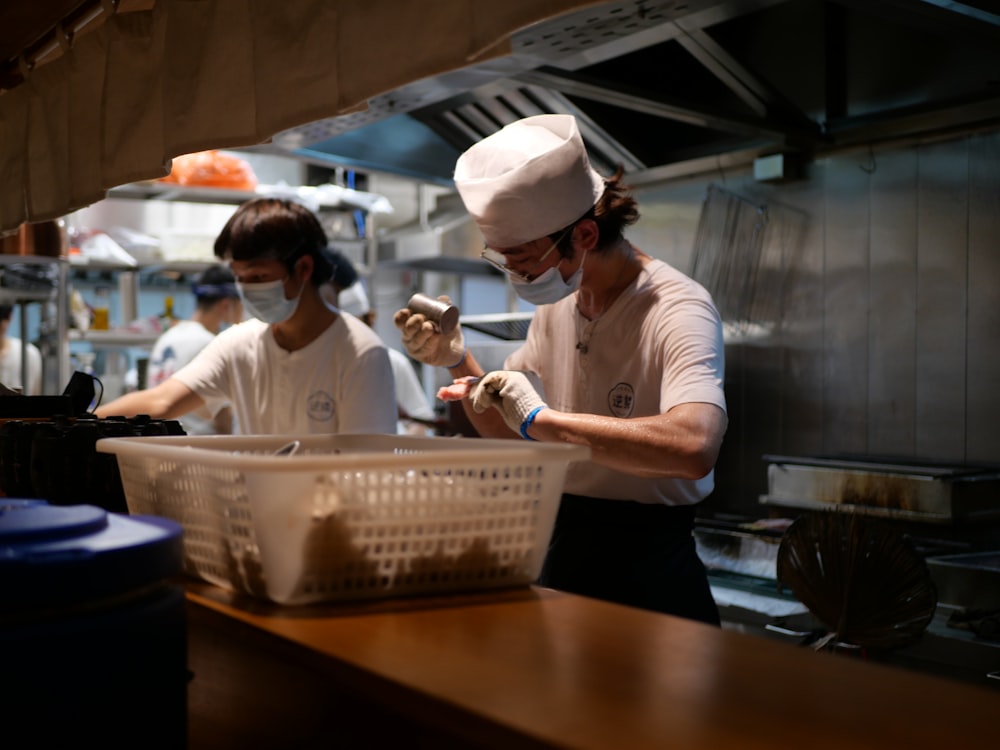 man in white chef uniform holding white plastic tray