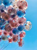 A vibrant personalized bubble balloon with colorful text floating against a bright sky.