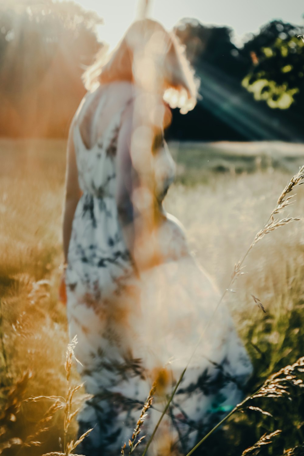 woman in white and black dress standing on brown grass field