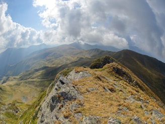 green and brown mountain under white clouds during daytime