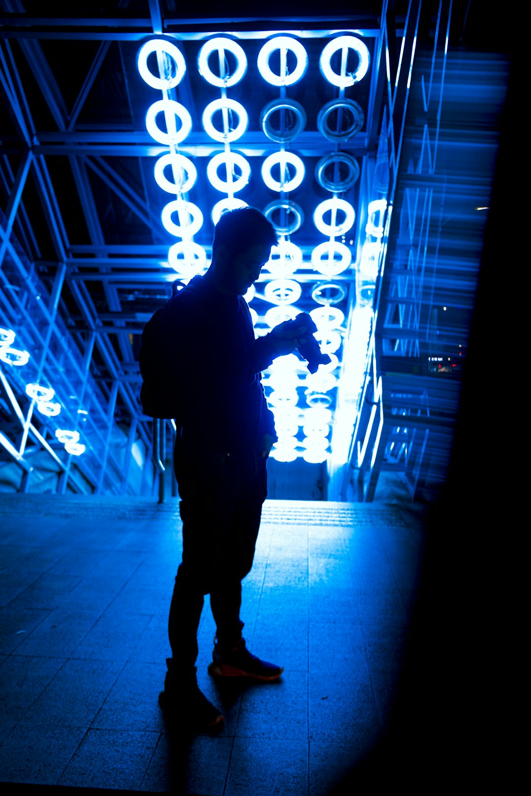 silhouette of man standing in front of lighted wall