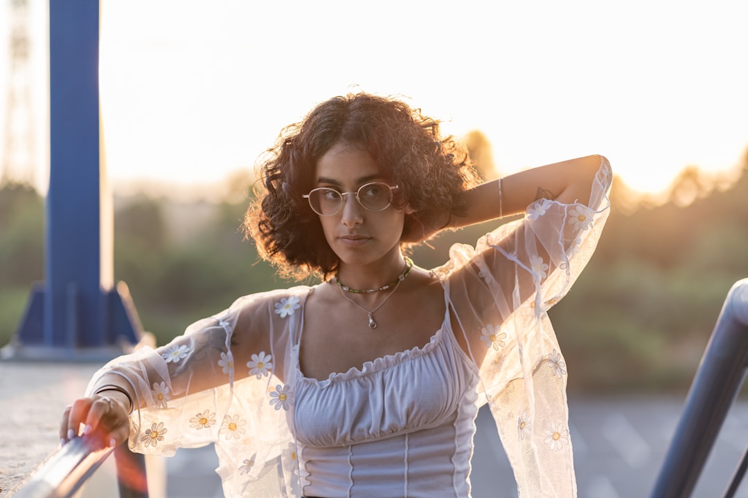 woman in white floral dress wearing black framed eyeglasses