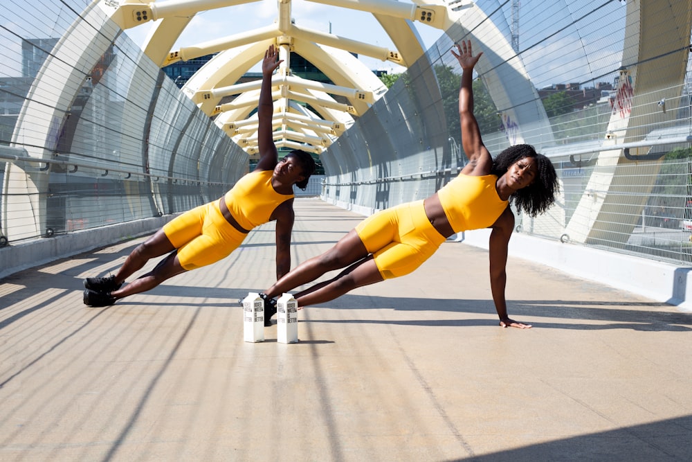 黄色いスポーツブラと黄色いショートパンツを着た女性が白い金属のフレームに飛び乗っています
