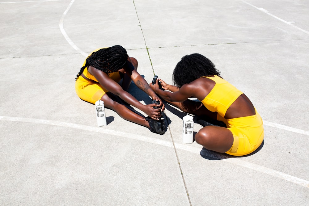 woman in yellow tank top and yellow shorts lying on floor