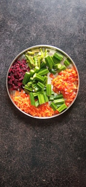 sliced carrots and green vegetable in stainless steel bowl
