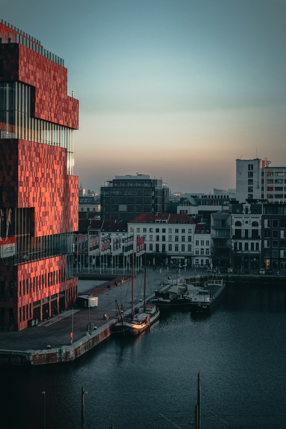 Edificio de hormigón rojo y blanco cerca del cuerpo de agua durante el día