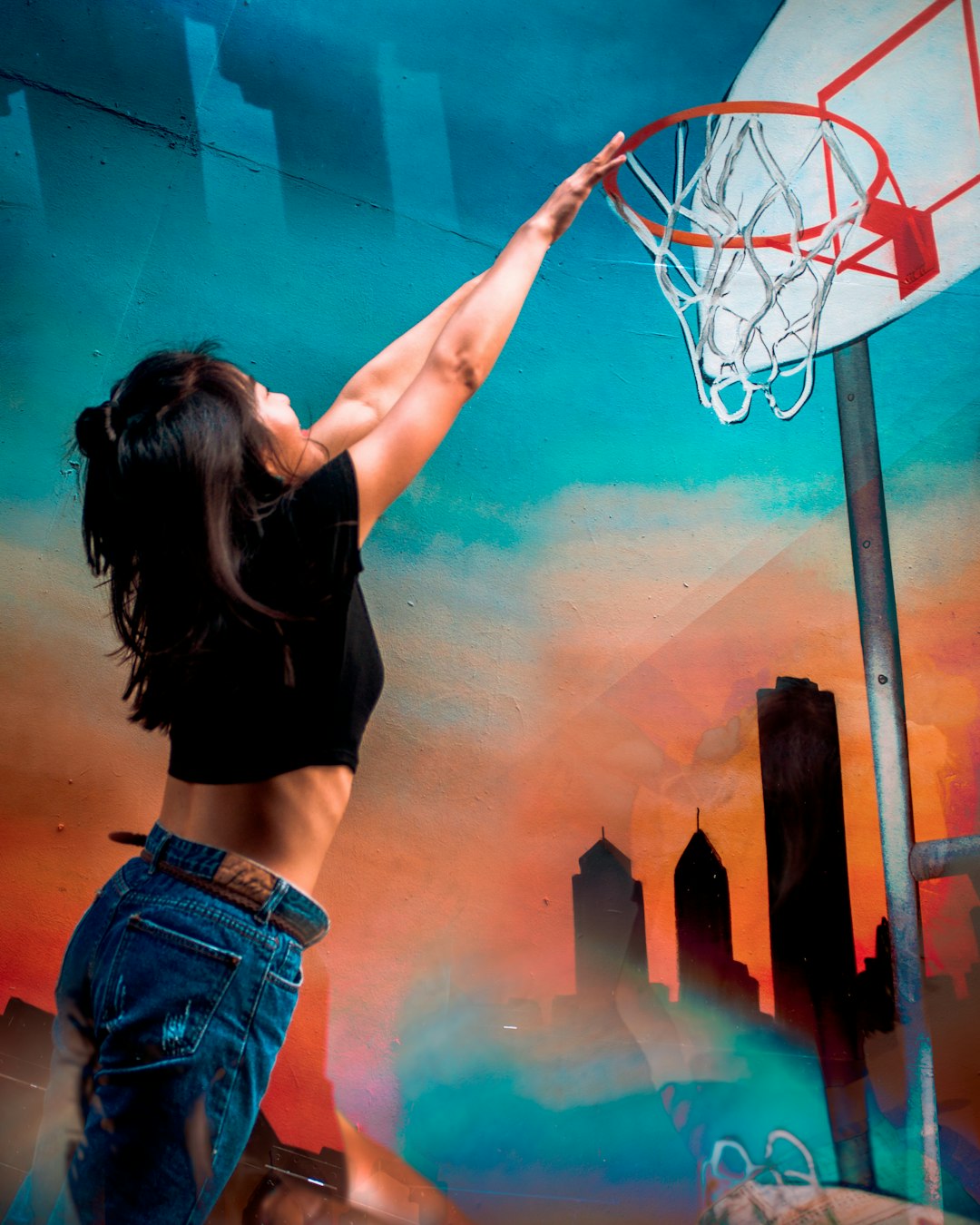 woman in black crop top and blue denim shorts standing and raising her right hand