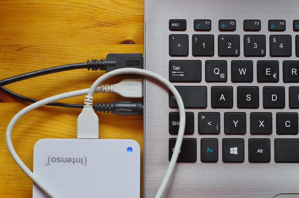 Weißes USB-Kabel auf grauem Laptop