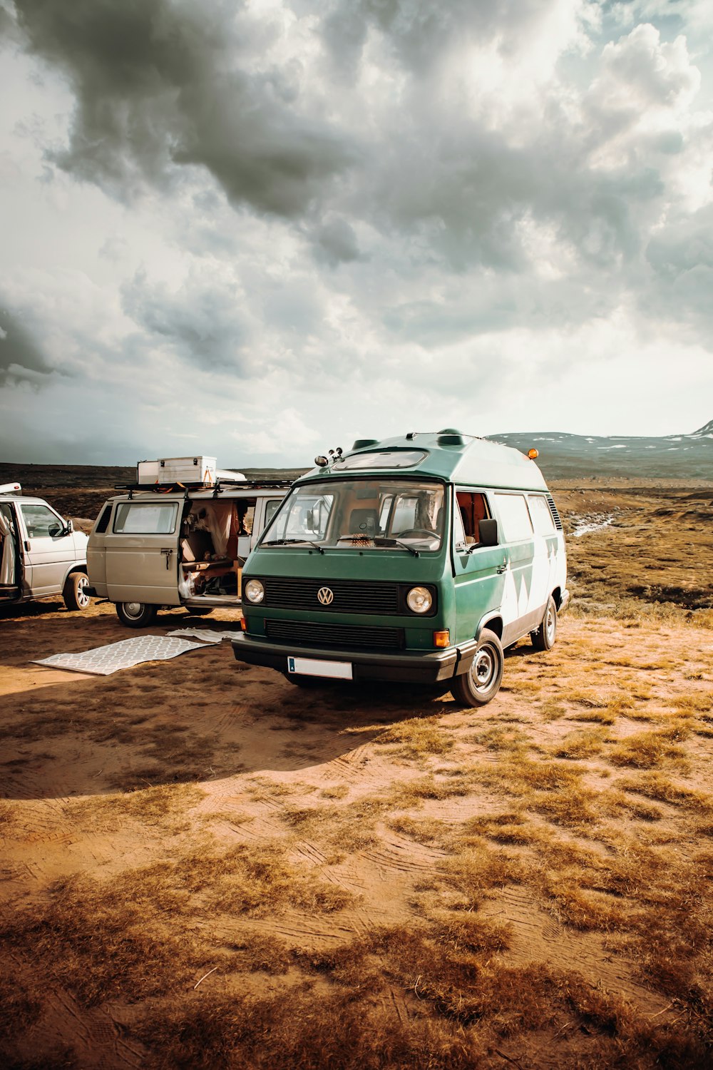 green and white van on brown sand under cloudy sky during daytime