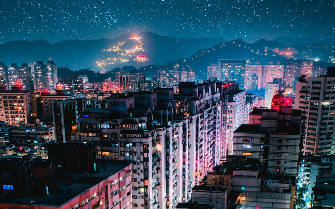 city with high rise buildings under blue sky during night time