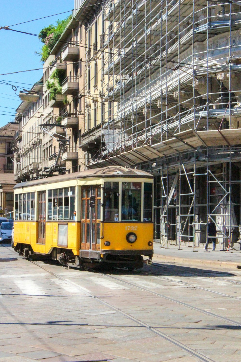 tranvía amarillo y blanco en la carretera cerca del edificio durante el día