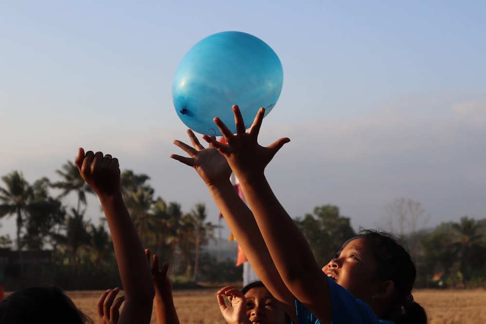 woman in black tank top holding blue balloon during daytime