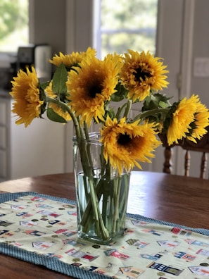 Bright sunflowers in a cheerful, hand-tied bunch on a wooden table