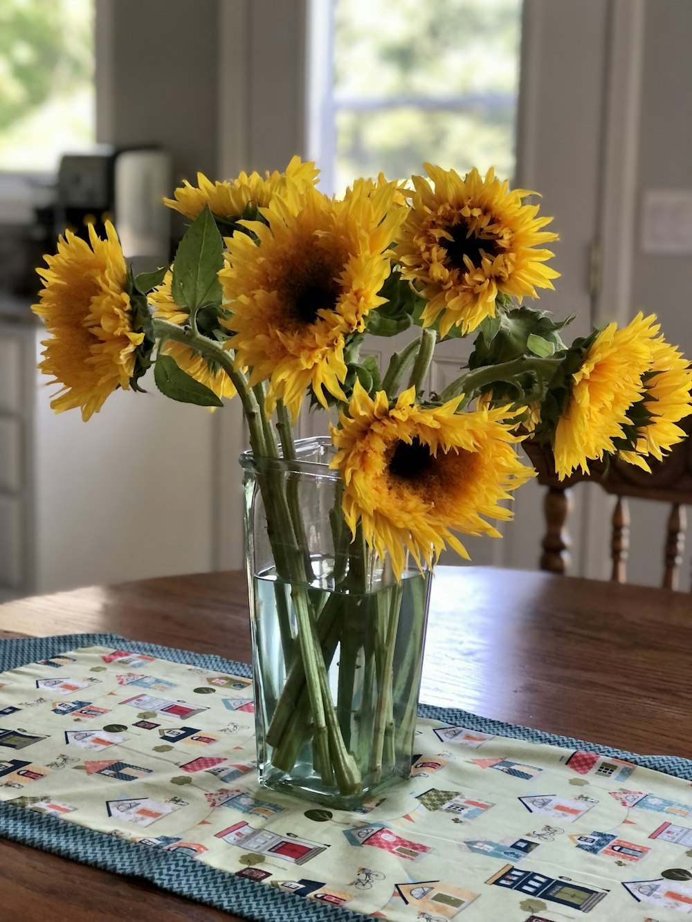 yellow flowers in clear glass vase