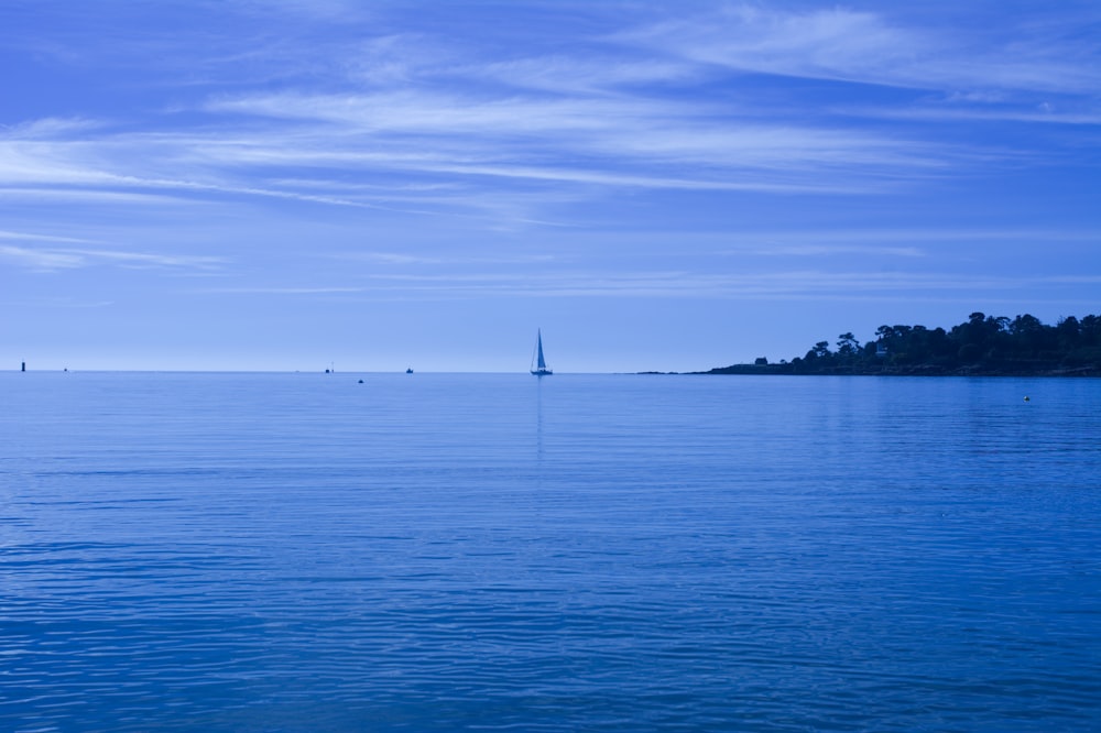 sailboat on sea under blue sky during daytime