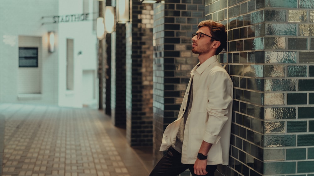 Homme en chemise blanche boutonnée et pantalon noir portant des lunettes de soleil noires debout dans le couloir