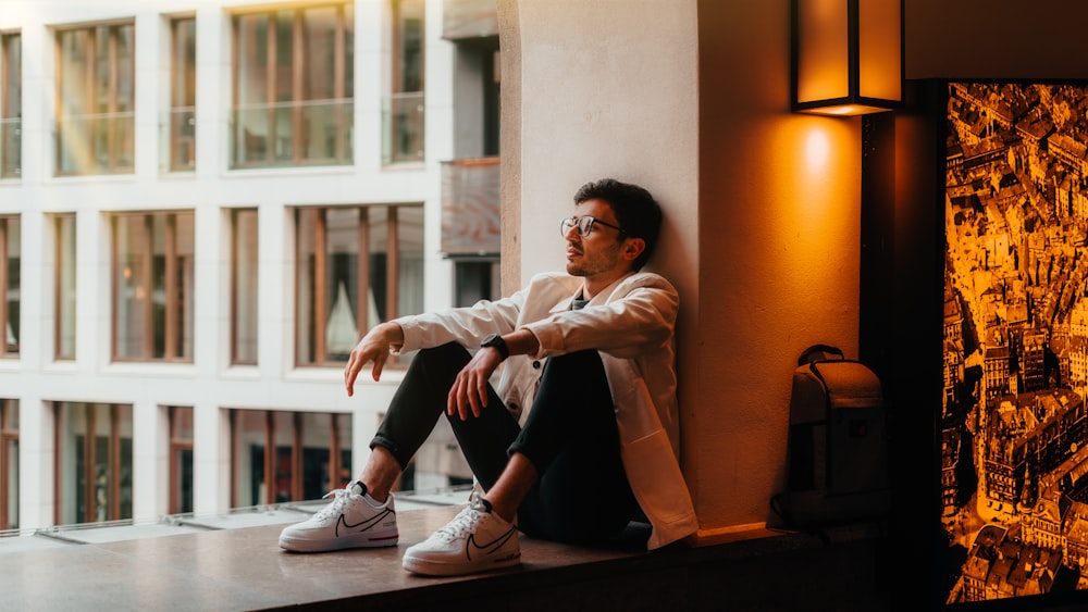 man in white dress shirt and black pants sitting on brown wooden bench