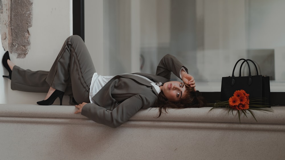 woman in gray long sleeve shirt lying on brown wooden bed