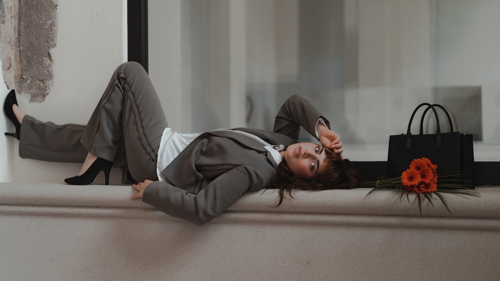 Femme en chemise grise à manches longues allongée sur un lit en bois marron