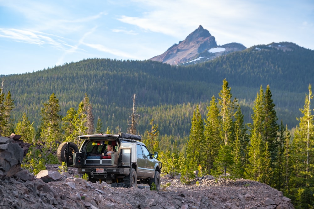 black suv on dirt road near green trees during daytime