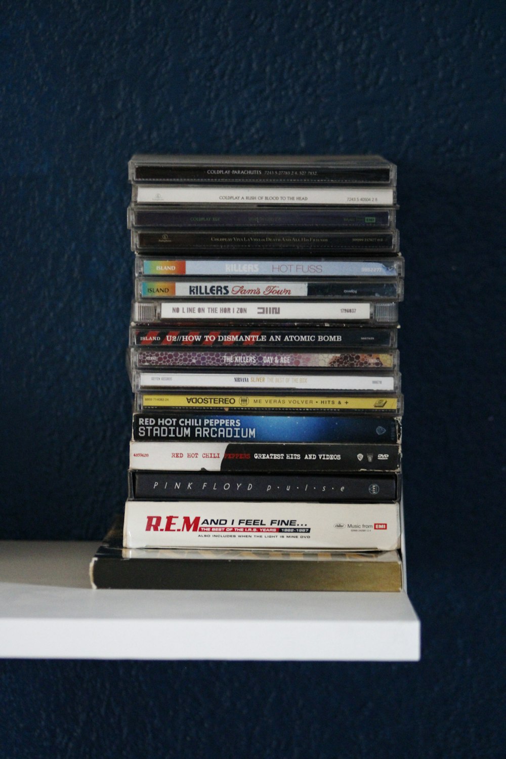 stack of books on white wooden shelf