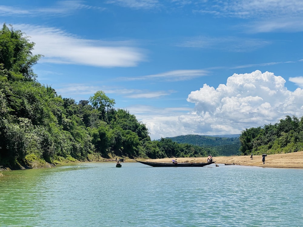 personnes à bord d’un bateau sur la rivière pendant la journée