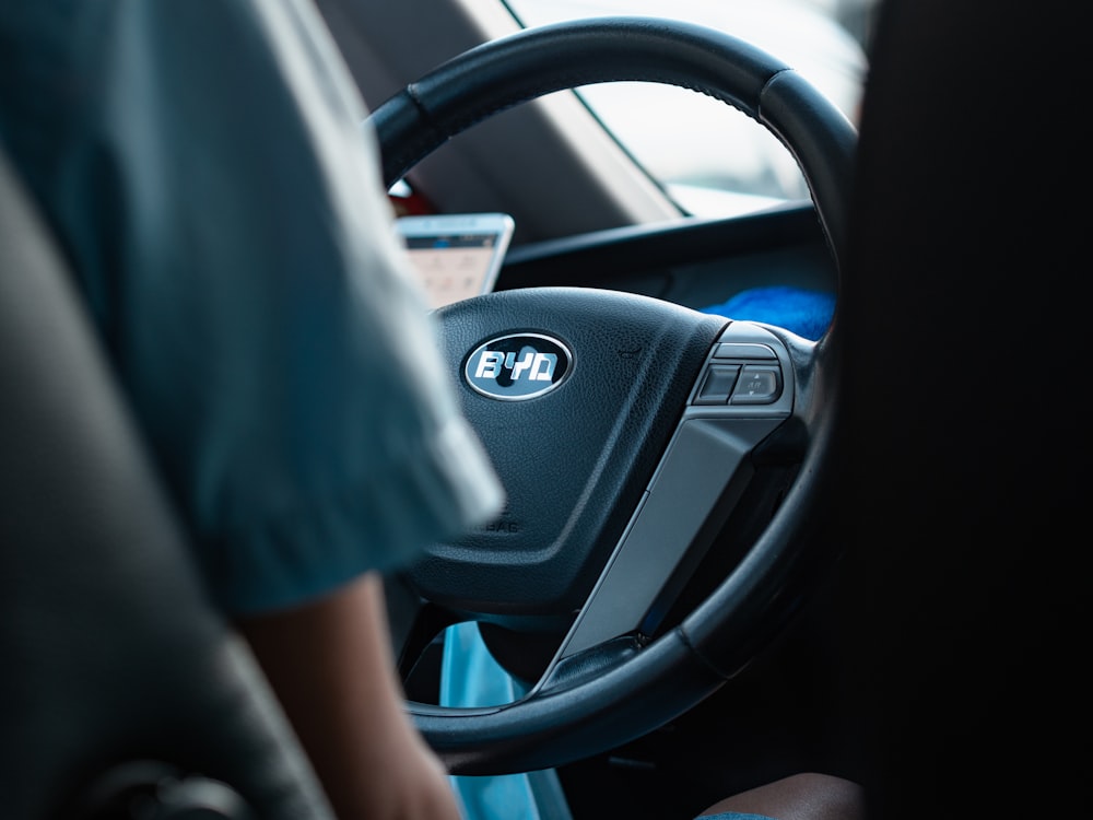 person in blue shirt driving car