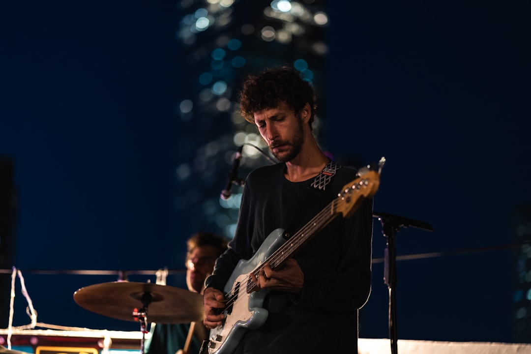 man in black crew neck t-shirt playing guitar