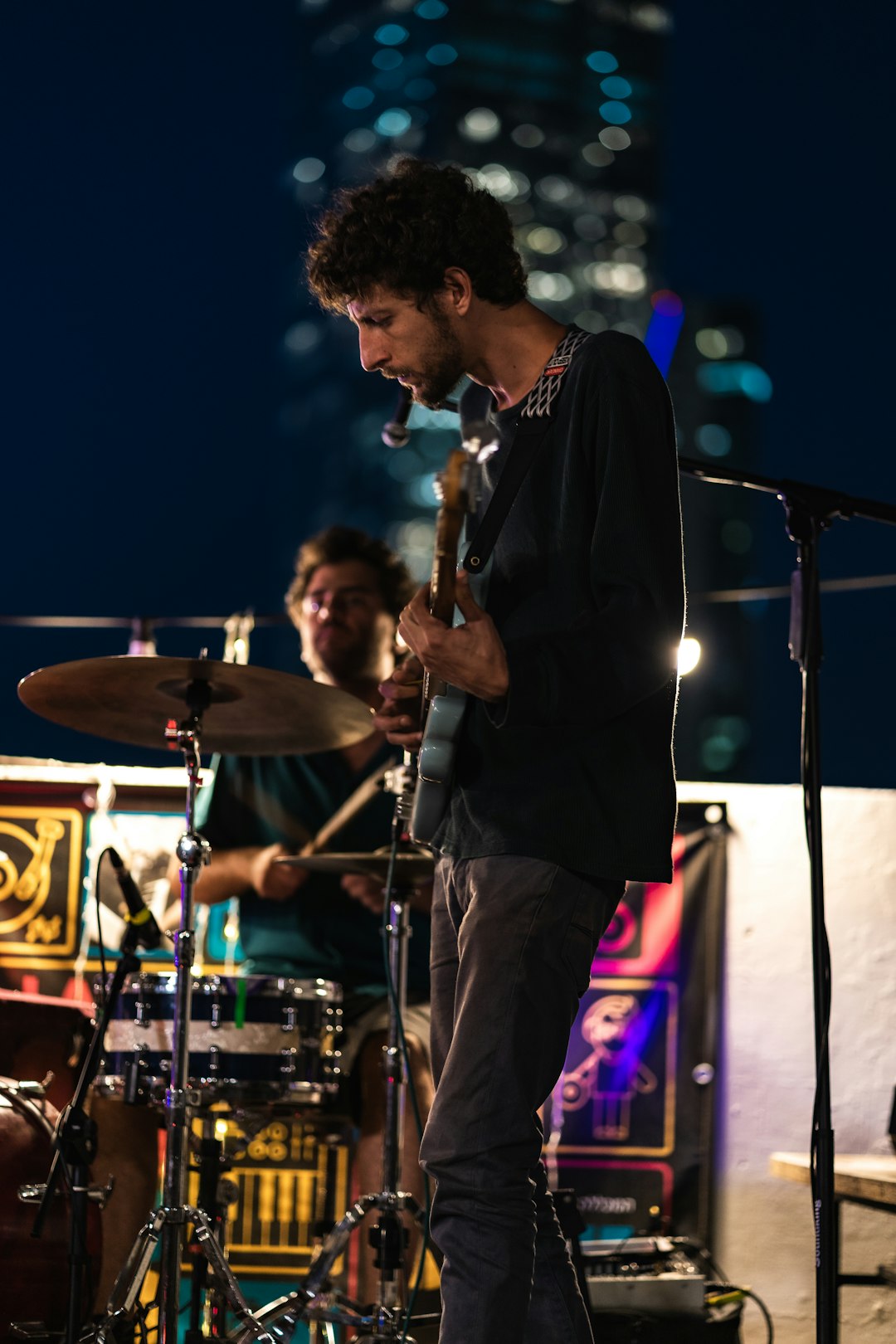 man in black suit singing on stage