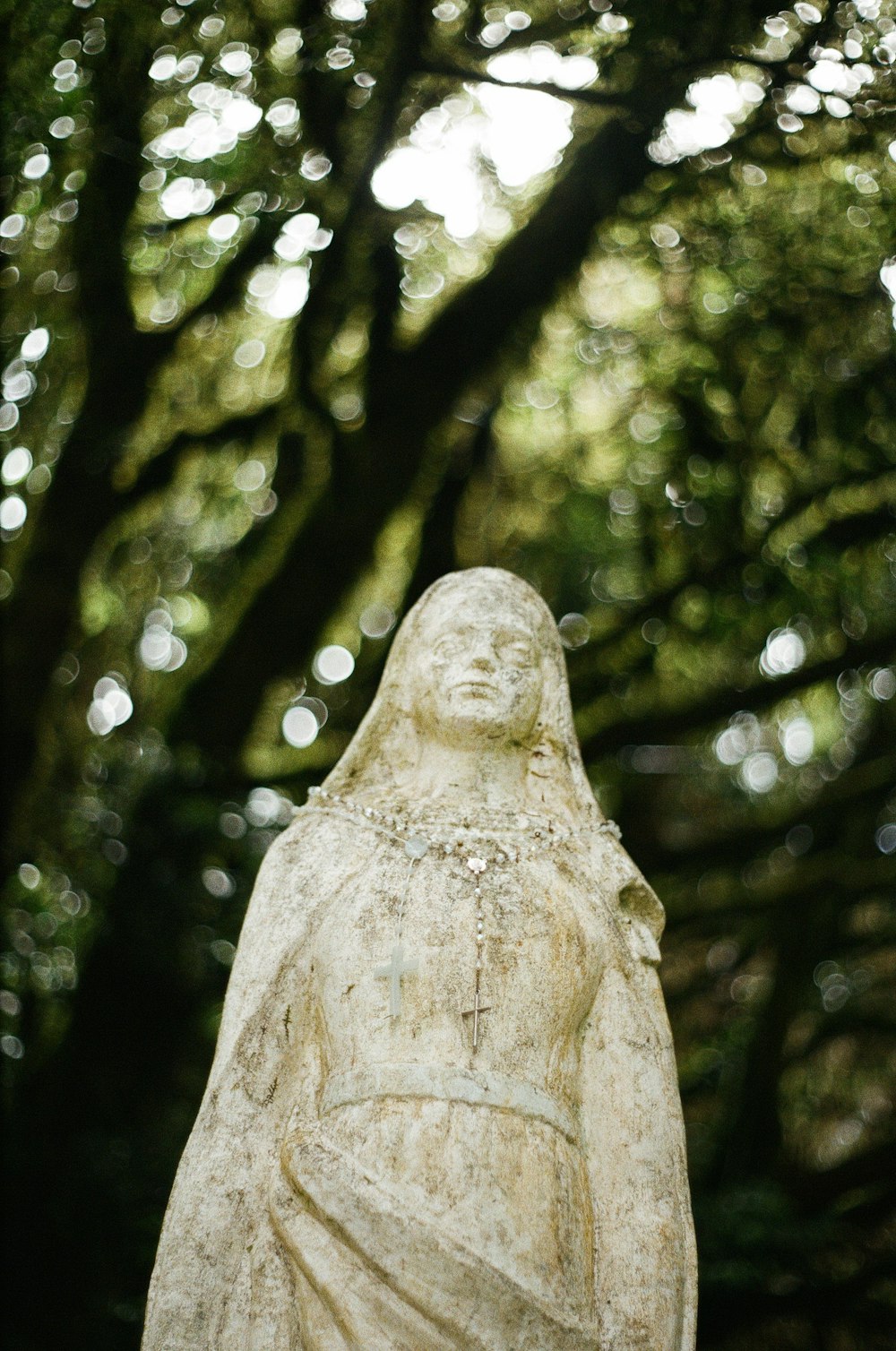 white concrete statue in forest during daytime