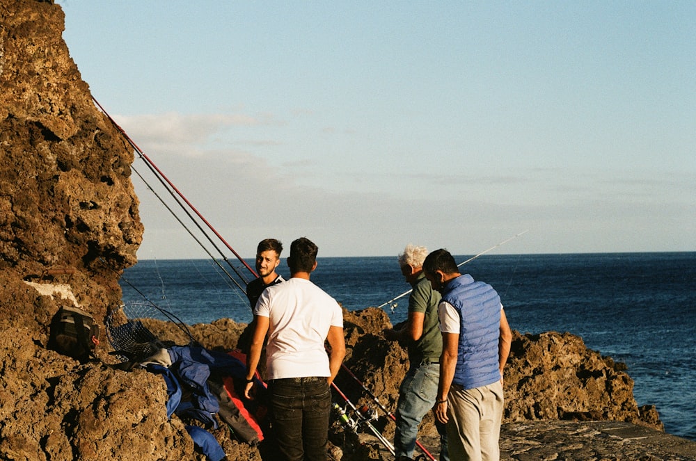 man in white t-shirt standing beside woman in black jacket on rock formation near body